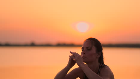 A-woman-performs-sit-UPS-at-sunset-on-the-beach-in-slow-motion.-Exercise-the-muscles-of-the-hips